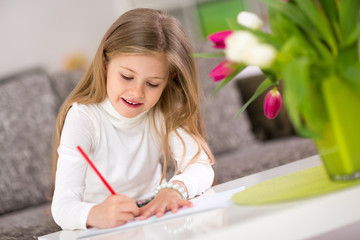 Happy little girl writing