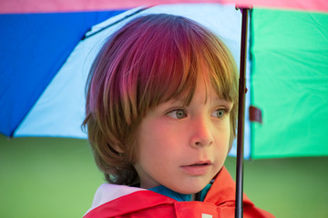 Little boy with umbrella in the rain