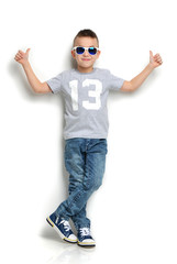 little boy in sunglasses standing and giving thumbs up sign