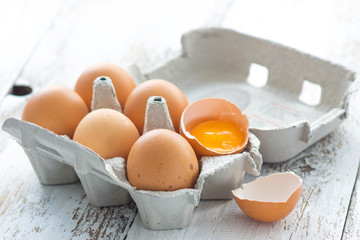 Cardboard box with eggs on wood
