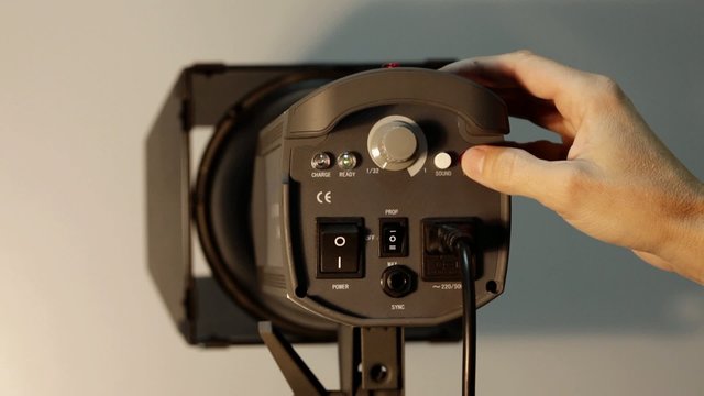 Photographer push test button on studio monoblock flash