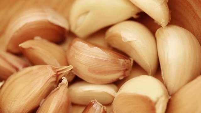 Fresh garlic cloves on rotating stand - closeup