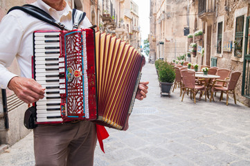 Accordion musician playing on alley of old Syracuse, Sicily, Italy © siculodoc
