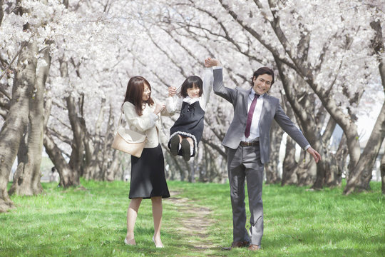 桜並木に立つ家族