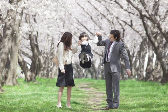 桜並木に立つ家族