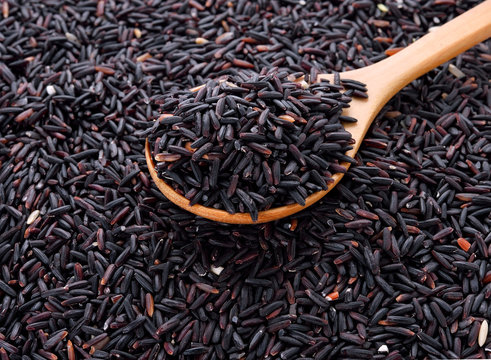 close up of rice berry rice with wooden spoon