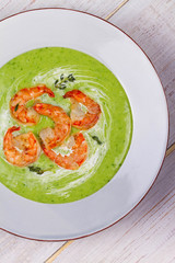 Green organic vegetable and creamy soup with shrimps
