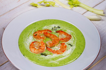 Green organic vegetable and creamy soup with shrimps