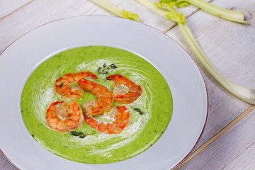 Green organic vegetable and creamy soup with shrimps