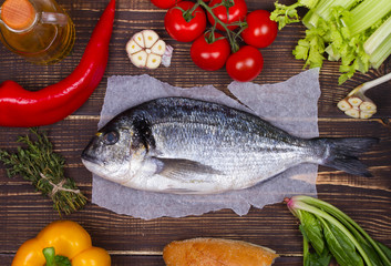 Delicious fresh fish and vegetables on dark vintage background