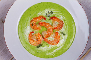 Green organic vegetable and creamy soup with shrimps