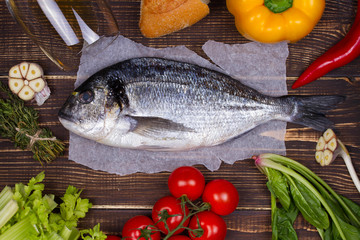Delicious fresh fish and vegetables on dark vintage background