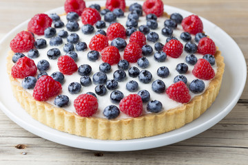 Cake with blueberries and raspberries. Confectionery product.