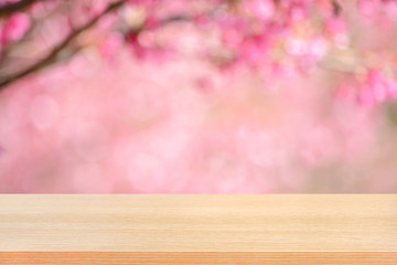 Wood table top on blurred pink cherry blossom flower background