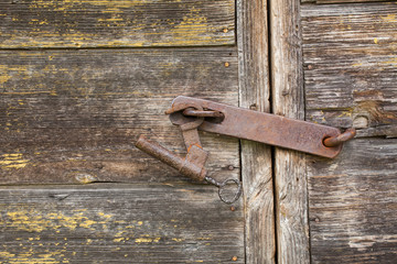 vintage rusty lock with a key on a wooden door