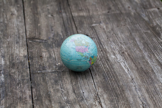 small globe lies on a wooden table
