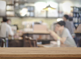 Empty wood table and blurred cafe with bokeh light background