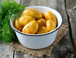 raw baby potatoes on wooden surface