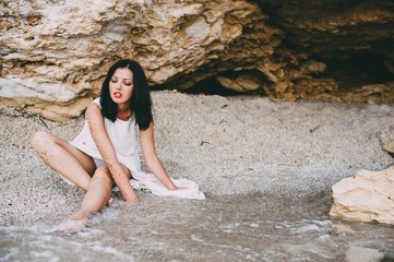 beautiful girl lies in a stone canyon on the beach, Greece