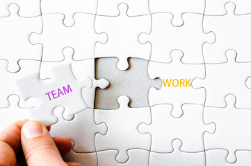 Missing jigsaw puzzle piece completing word TEAMWORK