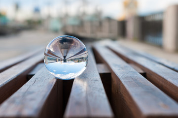 Glass transparent ball on wooden slats background. With empty