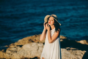 beautiful girl relaxes on the rock on the coast mole