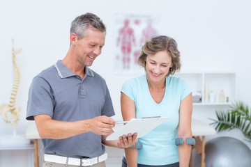 Obraz premium Woman using crutch and talking with her doctor