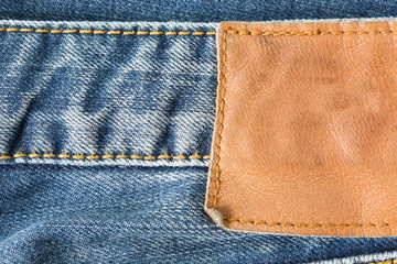 brown leather tag on blue jeans