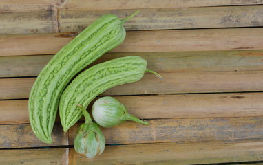 bitter gourd and egg plant on bamboo desk
