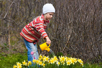 girl watering flowers with a watering-can