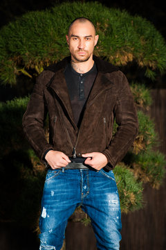  young man in  brown leather jacket pose in parck