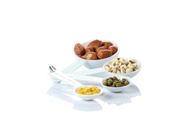 Beans in measuring spoons on white background