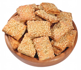 Cookies with sesame seeds in a wooden bowl on a white
