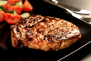Grilled steak and vegetables on dark