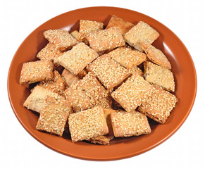 Cookies with sesame seeds on a ceramic plate on a white