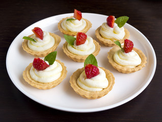 Many cakes with whipped cream, fresh fruits and mints