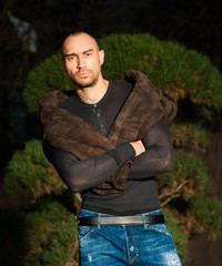  young man in brown leather jacket pose in parck