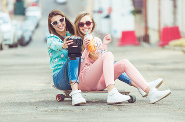 Hipster girlfriends taking a selfie in urban city context -