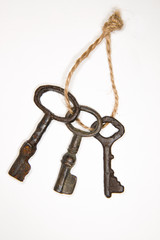 A lot vintage keys on a rope on white background