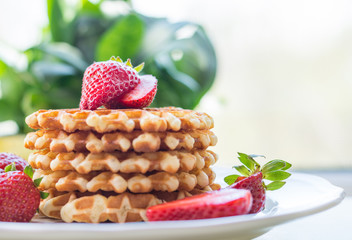 Belgian waffles with strawbery on white plate