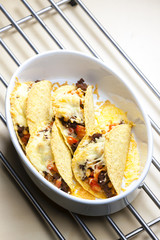 baked tacos filled with minced beef meat, beans and tomatoes