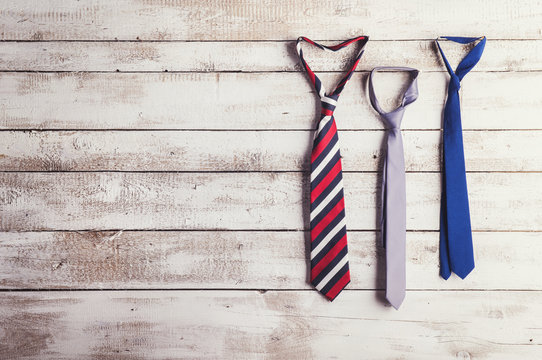 Fathers day composition of three ties on wooden background.