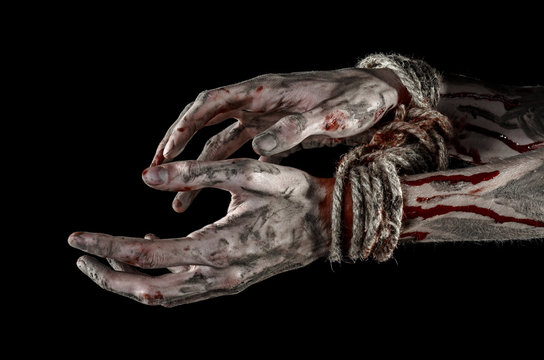 Hands bound,bloody hands, mud, rope, on a black background