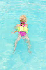Fototapeta na wymiar little girl swimming in the pool