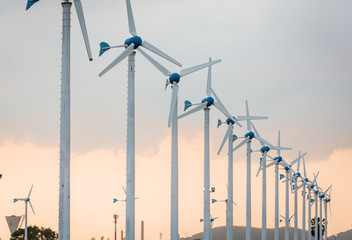Wind power station against and light sunset