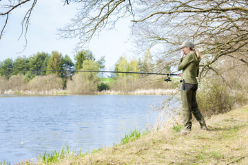 Fototapeta na wymiar woman fishing at pond in spring