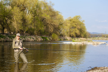 Fototapeta na wymiar woman fishing in the river in spring