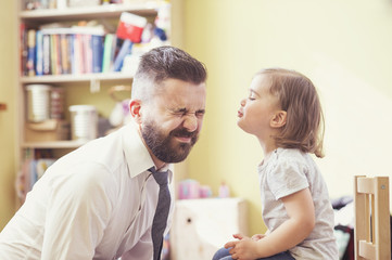 Young father spending time with his little daughter at home