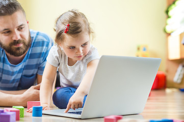 Young father spending time with his little daughter at home