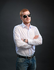 A man in a shirt and sunglasses on a black background